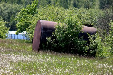 Su için büyük metal fıçı. Bahçede metal bir su varili duruyor. Tarım tarlasında eski paslı bir varil. 