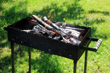 Boş ızgara ızgarası ve ateş alevi. Yemek ızgarası için kömüre ateş. Izgarada odun yakmak.