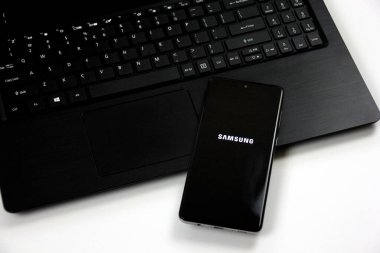 Riga, Latvia - june 17, 2021: Photo of a Samsung Galaxy A71 Android smartphone with android logo on black laptop. Software update on android smartphone