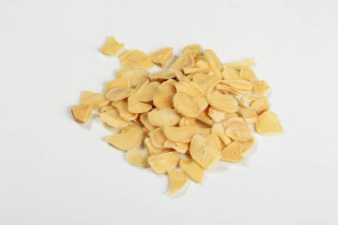 Dried garlic flakes on white background. Dried vegetables