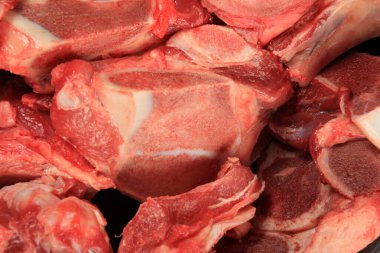 Arkaplanda çiğ et ve kemik var. Çiğ et ve sığır kemiği. Çorba için sığır kemiği seçimi. Seçici odaklanma. Çorba için sığır kemiği seçimi 