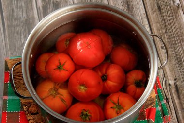 Red ripe tomatoes in a pot of hot water. Boiled Tomatoes. tomatoes poached in boiling water clipart