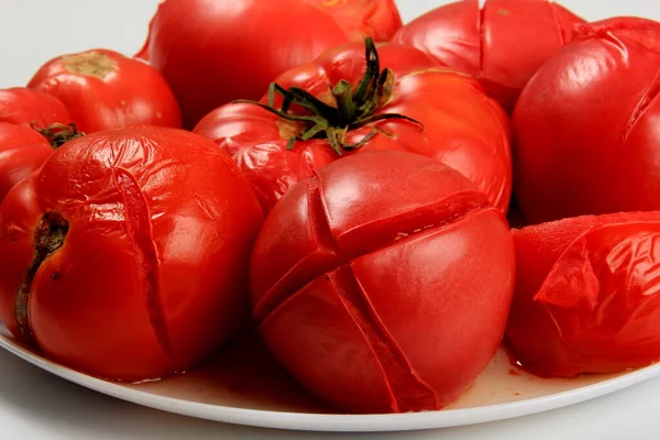 白い背景に赤トマトを漂白し剥離する準備ができて — ストック写真