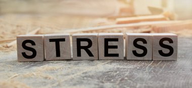 STRESS kelimesi tahta küplere yazılmıştır. Açık havada tahta küpler, kırsal alana tepeden bakan. İşle ilgili tasarım için. Pazarlama kavramı.