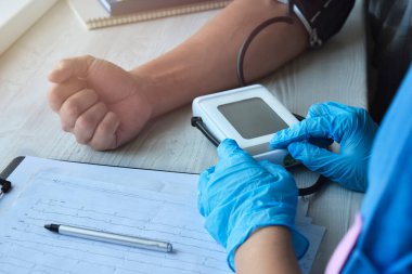 Bir doktor ya da eczacı hastane koğuşundaki bir hastanın basıncını ölçer. Tıbbi personel ve doktor hizmetleri. Sağlık hizmeti kavramı.