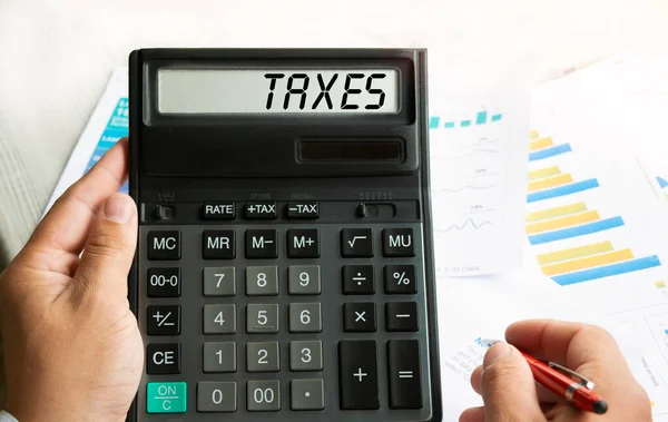 Ordet Taxes Skrivs Räknaren Affärsman Som Håller Miniräknare Handen Ovanifrån — Stockfoto