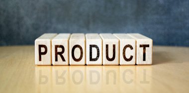 Tahta bir tahtanın arka planındaki tahta küplere yazılan prodüksiyon. İş, ekonomi ve finans kavramı.