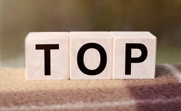 TOP kelimesi ahşap küplere yazılır. Açık havada tahta küpler, kırsal alana tepeden bakan. İşle ilgili tasarım için. Pazarlama kavramı.