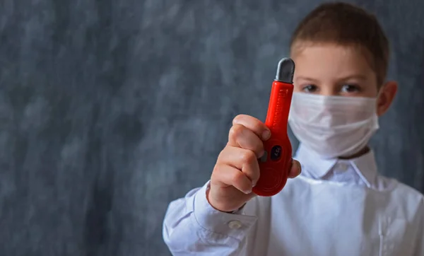 Tıbbi Maskeli Beyaz Üniformalı Küçük Sevimli Bir Çocuk Elinde Oyuncak — Stok fotoğraf
