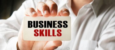 Elinde kartvizit tutan bir iş adamı. Harflerin içeriğinin iş konsepti ve pazarlama üzerinde etkileri vardır..