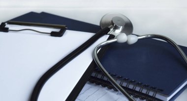 Tıbbi steteskop ve boş bir kağıt ile pano. Tıbbi konsept. Seçici odak.