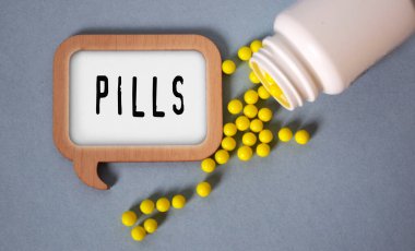 Şablondaki vitaminler dağınık hapların ve ilaç kavanozlarının arka planına karşı. Tıbbi konsept.