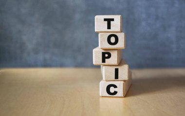 Tahta bir tahtanın arka planındaki tahta küplere TOPIC yazılıydı. Firma ve markanın tanıtımı için grafiksel kaynaklar.