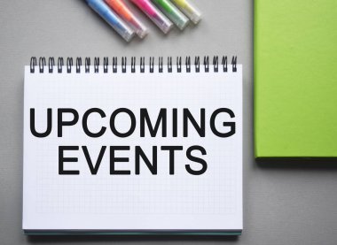 Motivasyon verici iş sözcükleri, alıntılar, tipografi. Kavramsal görüntü. Masada duran bir defterin ve ofis malzemelerinin üst görüntüsü, karanlık bir arkaplanda. Pazarlama.