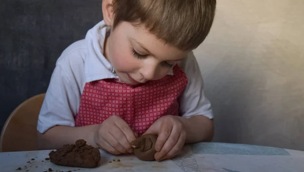 Çamurdan yapılmış şirin bebek heykelleri. El işi, çömlek, çocuk sanatı, eğitim, evde oynamak. Ilık ışık, seçici odak resim ve gürültü efektleri.