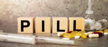 Harfli bir metin olarak PILL, metin için boşluk ile koyu gri arkaplan üzerinde kelime küpleri ile Corona virüsü salgını.