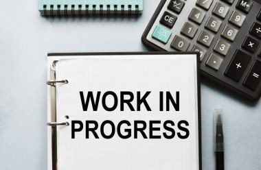 Defterdeki yazıda iş ya da pazarlama içeriği var. Çalışma masasının üst görüntüsü, iş aksesuarları, hesap makinesi. Finans ya da iş konsepti.