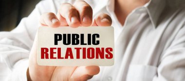 Elinde kartvizit tutan bir iş adamı. Harflerin içeriğinin iş konsepti ve pazarlama üzerinde etkileri vardır..