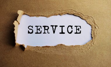 Yırtık kağıdın arkasında beliren SERVICE metni. El işi kağıdı yırtılmış..