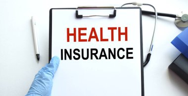 Belgeler için bir tablet, steteskop ve beyaz arka planda dokümanlar olan bir doktorun elleri. Yukarıdan bak. Sağlık hizmeti kavramı.
