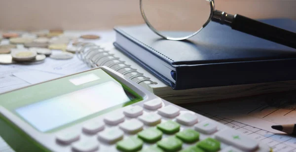 Not defteri, hesap makinesi ve büyüteç masaüstünde. Ofis ekipmanları iş yerinde. Ofis çalışmalarının kavramsal görüntüsü.