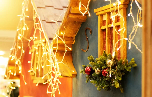 Dış görünüş için şehir Noel süsleri. Evin penceresinde Noel çelengi yanıyor. Şenlikli ışıklandırma. Yeni yıl dekoru. Avrupa mahsulü