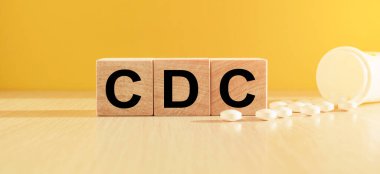 Parlak sarı arkaplanı ve dağınık tabletleri olan tahta küpleri. Tıbbi konsept