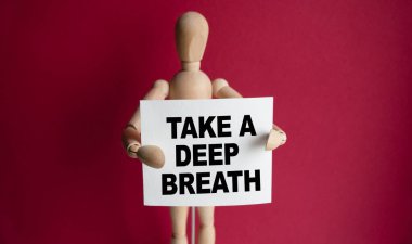 Tahta adam elinde beyaz bir tabela tutuyor ve elinde derin bir nefes alıyor. Harflerin içeriğinin iş konsepti ve pazarlama üzerinde etkileri vardır..