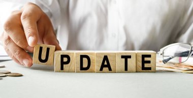 Tahta küplerin dokusuyla ilgili UPTE yazıtları. Bir iş adamı elinde bir küp tutuyor. Finansal, ticari ya da ekonomik tema üzerine bir yazı.