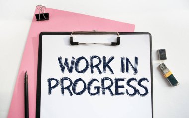 Klipsli bir klasör. Progres Çalışması. İş aksesuarlarıyla birlikte çalışma masasının üst görüntüsü. Finans ya da iş konsepti.