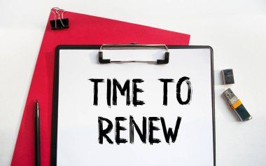 Yeniden Yenilenme Zamanı etiketli bir klipsli klasör. İş aksesuarlarıyla birlikte çalışma masasının üst görüntüsü. Finans ya da iş konsepti.