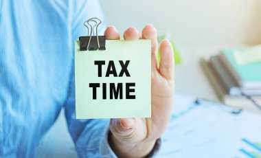 Vergi İdaresi, kadın bir işadamı tarafından gösterilen bir kuponda yazıyor. Yumuşak odak.