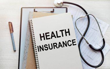 Defterde tıbbi bir tema üzerine bir yazı var. Tıbbi kayıtları ve steteskopu olan bir defterin üst görüntüsü. sağlık hizmeti kavramı