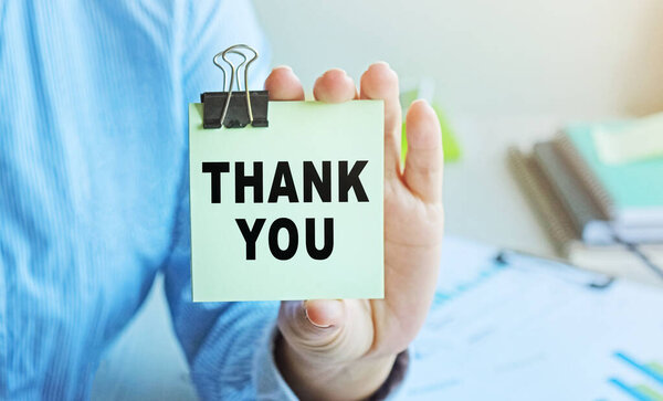 THANK YOU написано на ваучере, предъявленном женщиной-бизнесменом. Мягкий фокус.