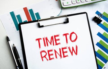 Yeniden Yenileme Zamanı etiketli bir klipsli klasör. Belgeler, çizelgeler ve iş aksesuarlarıyla birlikte bir masaüstü görüntüsü. Finans ya da iş konsepti.