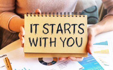 Elinde tabela olan açık renk elbiseli bir kız masada oturuyor. Seninle başlamasına izin vermekle. İçerik harfleri iş kavramına karşılık gelir.