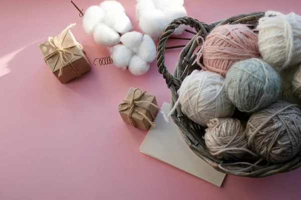 İçinde iplik yumakları olan sepet. Hediye kutuları. Tatil için dekorasyon. Hassas renkler, pembe arkaplan.