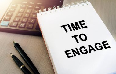 Deftere yazılmış bir mesaj. Hesap makineli masaüstü görünümü. Yumuşak güneş ışığı. İçerik harfleri iş içeriği, finans veya pazarlama için gereklidir.