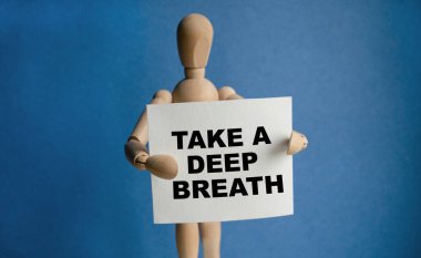 Tahta adam elinde beyaz bir tabela tutuyor ve elinde derin bir nefes alıyor. Harflerin içeriğinin iş konsepti ve pazarlama üzerinde etkileri vardır..