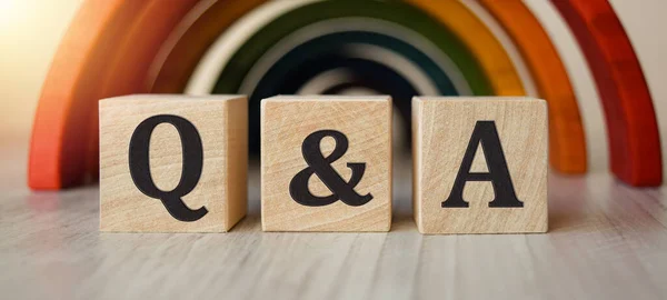 Mergers and acquisitions, business concept Q and A. Letters on wooden cubes