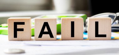 Tahta küplerin dokusunda başarısız bir yazı var. Bir iş adamı elinde bir küp tutuyor. Finansal, ticari ya da ekonomik tema üzerine bir yazı.