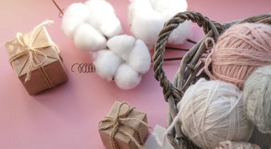 İçinde iplik yumakları olan sepet. Hediye kutuları. Tatil için dekorasyon. Hassas renkler, pembe arkaplan.