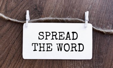 Metni yaymak kelime bir kağıt parçası üzerine yazılır sarma vidaları ile birlikte. Yukarıdan bak. Üzerinde yazı olan rozet ahşap bir masada duruyor. Yaratıcı harfler.