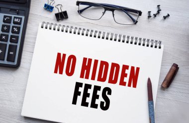 Notepad with the inscription NO HIDDEN FEES. Conceptual image, business accessories, calculator isolated on the desktop. Finance or business concept.