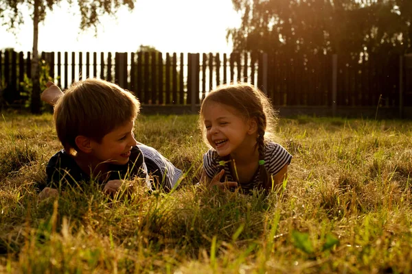 一个男孩和一个女孩躺在自然界中修剪过的草地上 在农村休息 在农村生活 — 图库照片