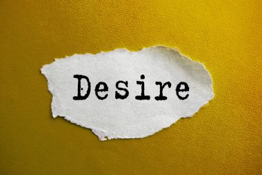 Yırtık kağıda DESIRE yazılıydı. Sarı arka planda pazarlama kavramsal kelime.