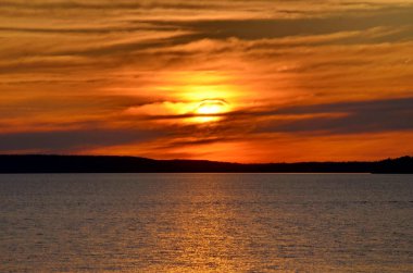 Prens Albert Ulusal Parkı, Saskatchewan, Kanada 'da suyun üzerinde gün batımı.