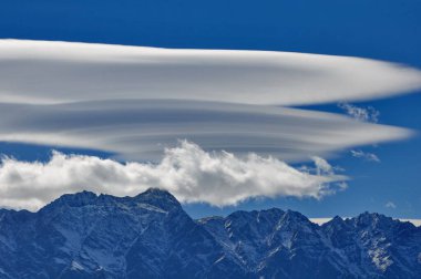 Lenticular clouds over the mountains at Queenstown, New Zealand. clipart