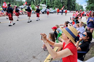 Waskesiu, Saskatchewan, Kanada - 1 Temmuz 2019: The Prince Albert Highlanders Band ve bir RCMP ve Parks Canada Color Guard Kanada bayramını kutlamak için Prince Albert Ulusal Parkı 'nda yürüyüş.