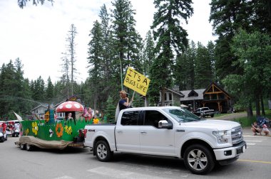 Waskesiu, Saskatchewan, Canada - July 1, 2019: Colorful parade floats and people take part in a parade to celebrate Canada Day in Prince Albert National Park.